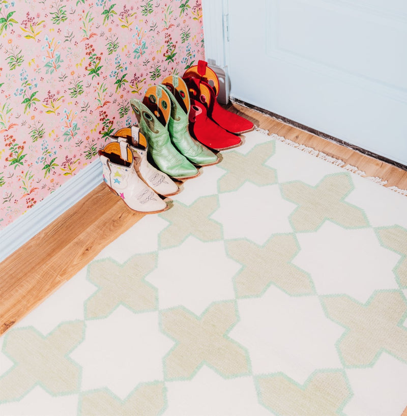 Colorful boots on a patterned floor with floral wallpaper